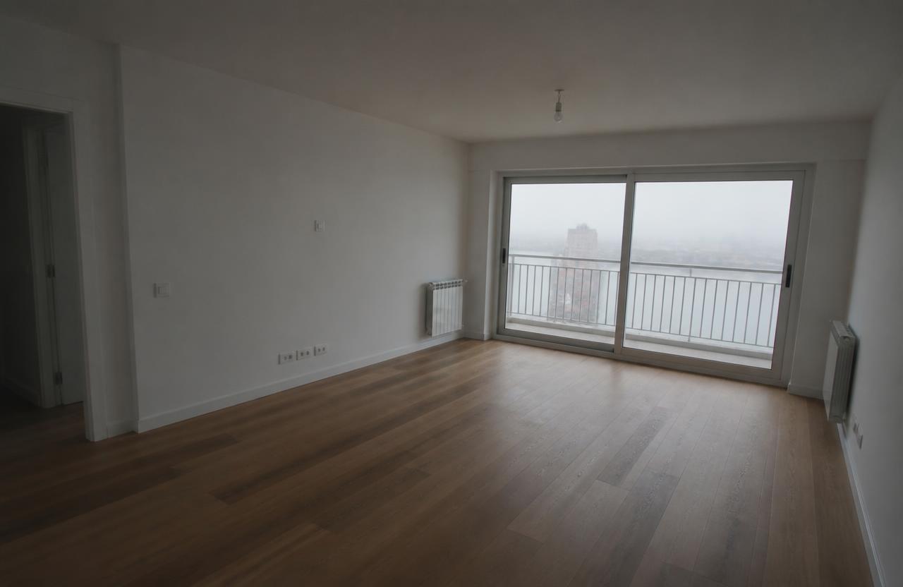 Original unedited listing photo of an empty living room with flat, dull lighting.